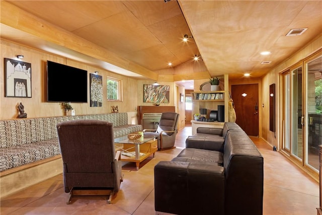 living area with wooden walls, visible vents, and tile patterned flooring