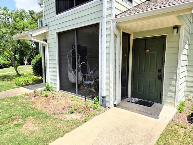 view of exterior entry featuring a yard