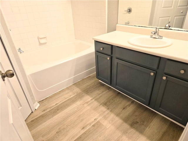 bathroom featuring hardwood / wood-style floors, vanity, and shower / washtub combination