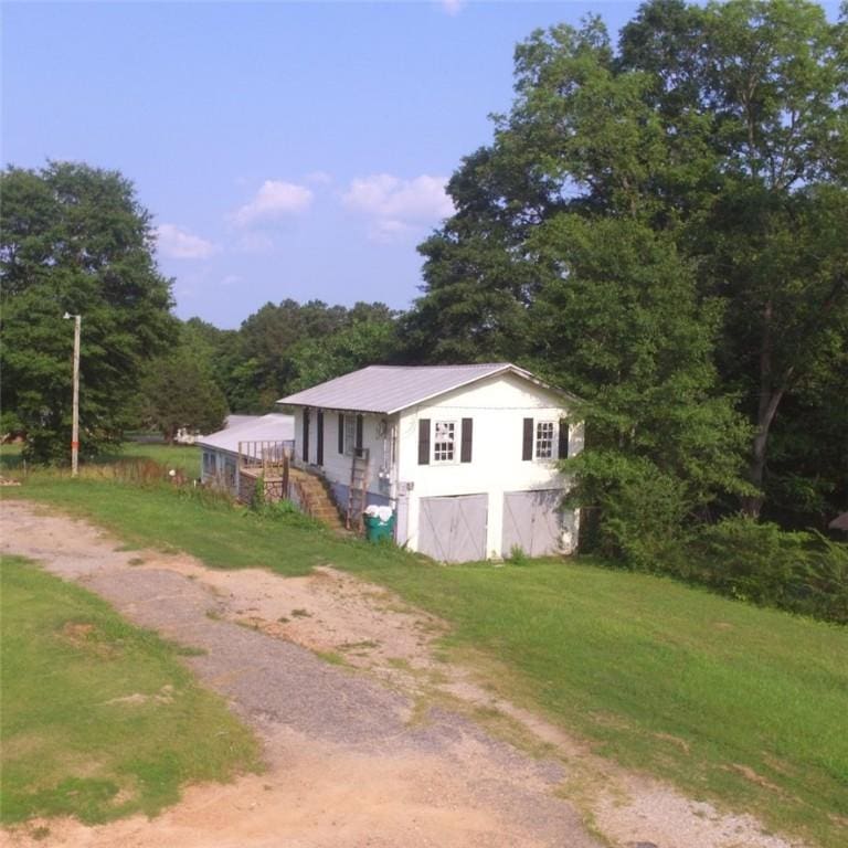 251 1st St NE, Lafayette, AL 36862 - view of side of property with dirt driveway, a yard, and a metal roof