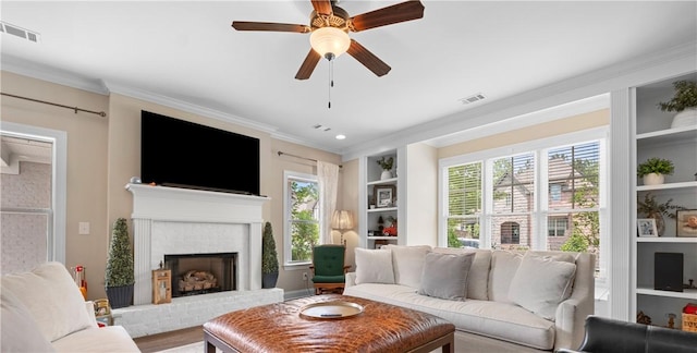 1195 Southridge Ct, Auburn, AL 36830 - living room with built in features, crown molding, ceiling fan, a fireplace, and healthy amount of natural light