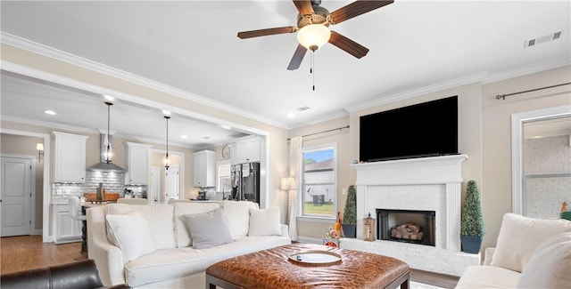 1195 Southridge Ct, Auburn, AL 36830 - living room featuring a ceiling fan, wood finished floors, crown molding, a brick fireplace, and recessed lighting