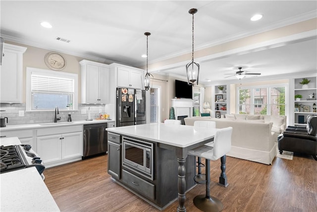 1195 Southridge Ct, Auburn, AL 36830 - kitchen featuring stainless steel appliances, a sink, a breakfast bar, a ceiling fan, and a fireplace