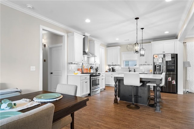 1195 Southridge Ct, Auburn, AL 36830 - kitchen featuring stainless steel appliances, wall chimney range hood, a kitchen breakfast bar, white cabinetry, and light countertops