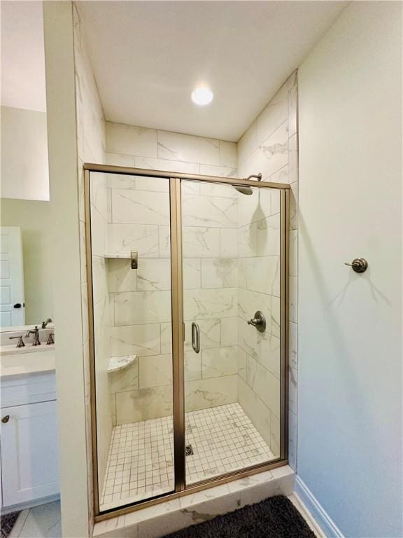 full bathroom featuring vanity, baseboards, and a stall shower