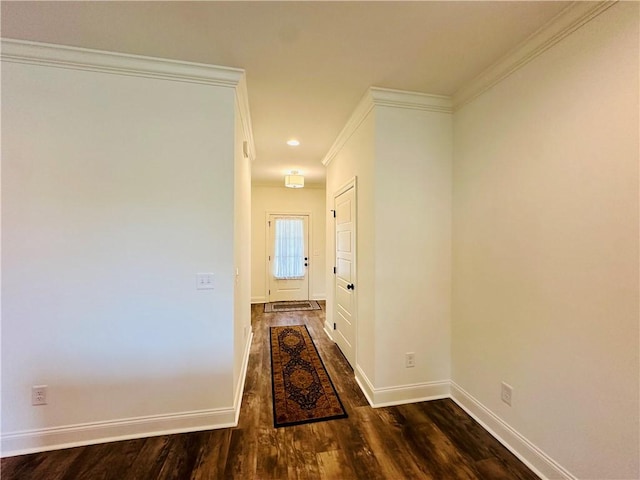 hallway featuring baseboards, ornamental molding, and dark wood finished floors
