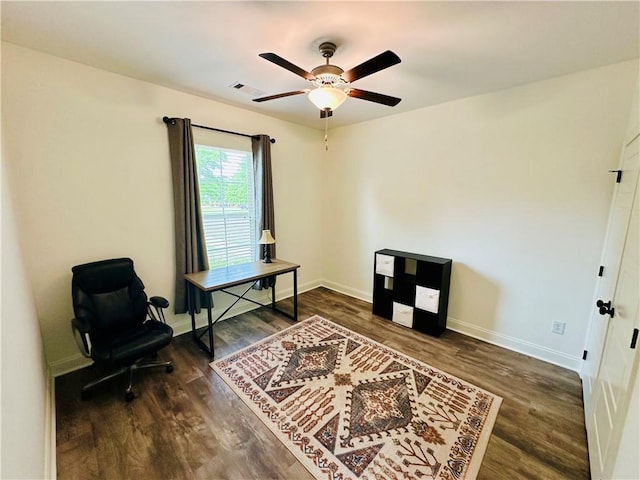 home office featuring dark wood finished floors, visible vents, baseboards, and ceiling fan