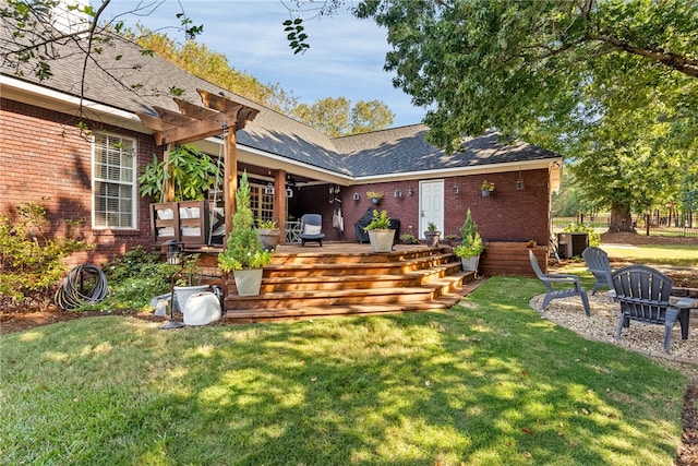 rear view of house with a yard, a pergola, and a wooden deck