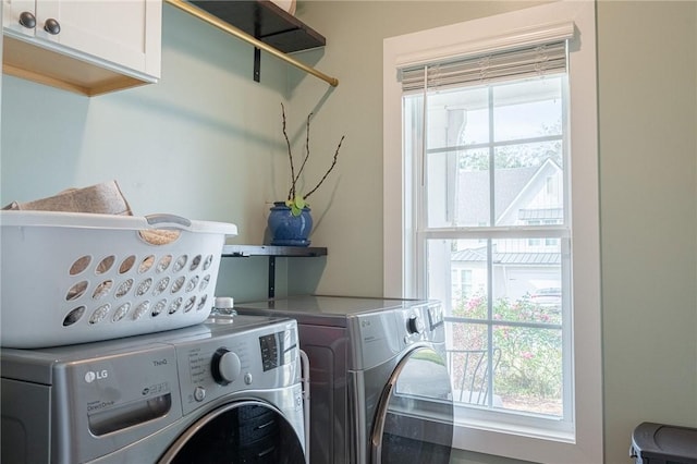 washroom with cabinets and washing machine and dryer