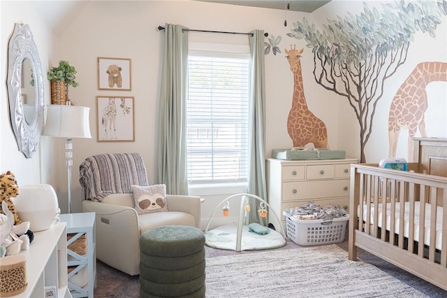 carpeted bedroom with vaulted ceiling and a nursery area