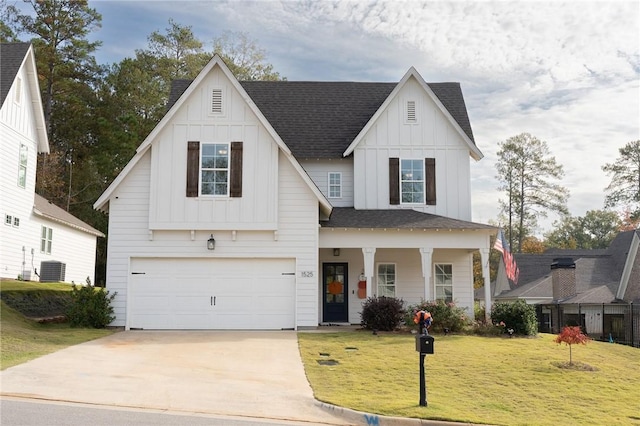 view of front of home featuring a front yard, a porch, and a garage