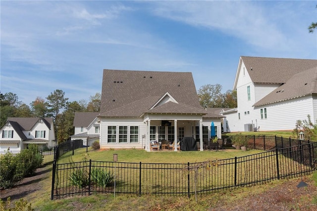 rear view of property with a yard and ceiling fan