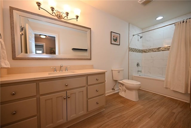 full bathroom with hardwood / wood-style floors, toilet, vanity, and shower / tub combo