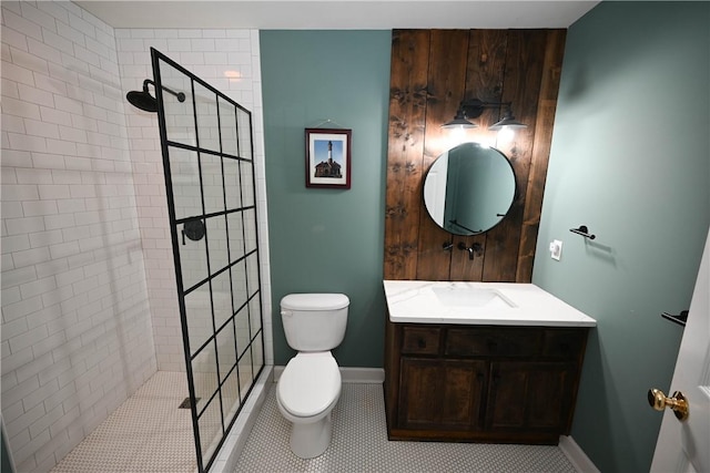 bathroom featuring tile patterned floors, toilet, vanity, and tiled shower