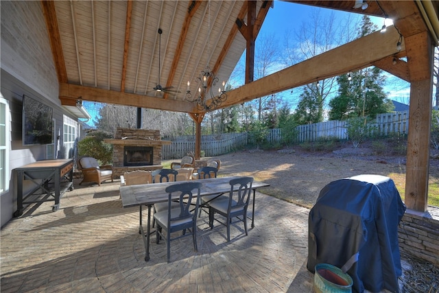 view of patio featuring ceiling fan, an outdoor stone fireplace, and grilling area