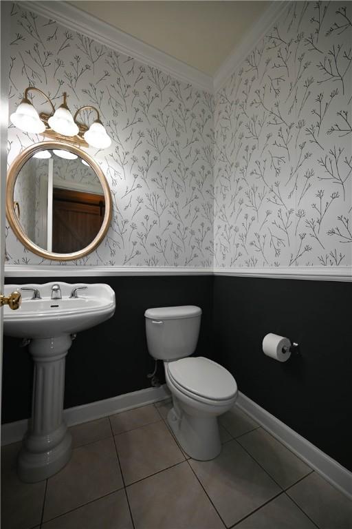 bathroom featuring toilet, ornamental molding, and tile patterned flooring