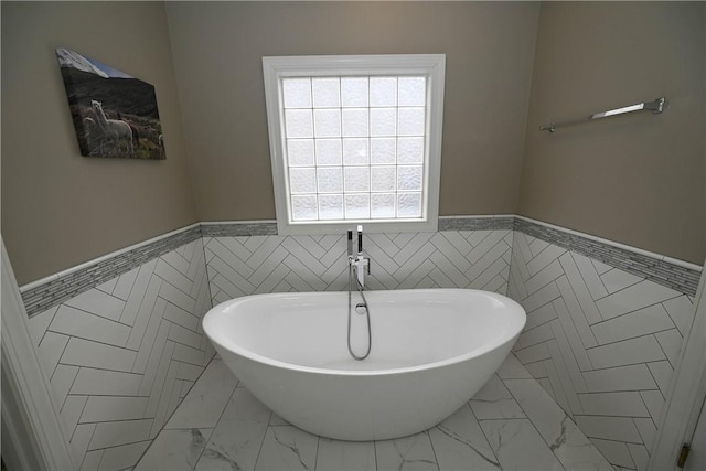 bathroom with tile walls and a bath