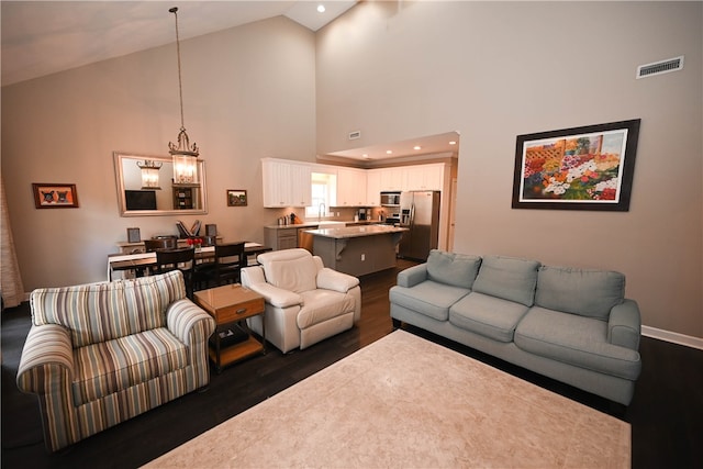 living room featuring high vaulted ceiling, dark wood-type flooring, and sink