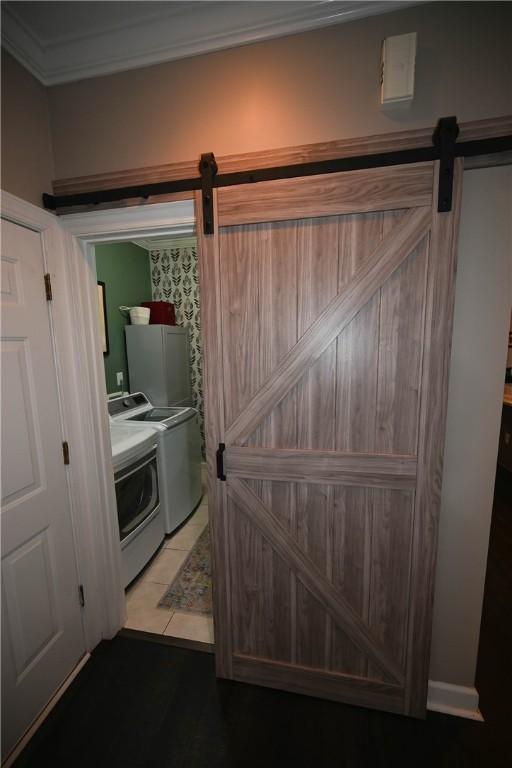 bathroom with washer and clothes dryer and tile patterned floors