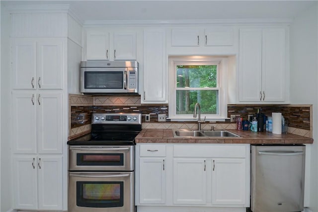 222 Green St, Auburn, AL 36830 - kitchen featuring appliances with stainless steel finishes, a sink, white cabinetry, and tasteful backsplash