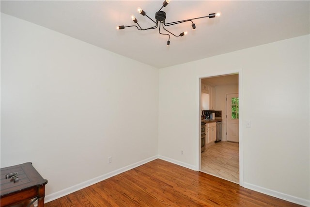 222 Green St, Auburn, AL 36830 - empty room with a chandelier, light wood-style floors, and baseboards