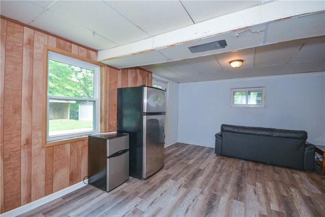 222 Green St, Auburn, AL 36830 - kitchen featuring freestanding refrigerator, wood walls, and light wood-type flooring