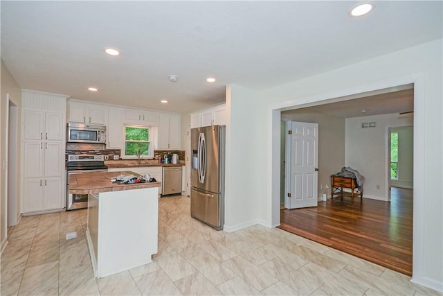 222 Green St, Auburn, AL 36830 - kitchen featuring stainless steel appliances, white cabinets, tasteful backsplash, a kitchen island, and recessed lighting
