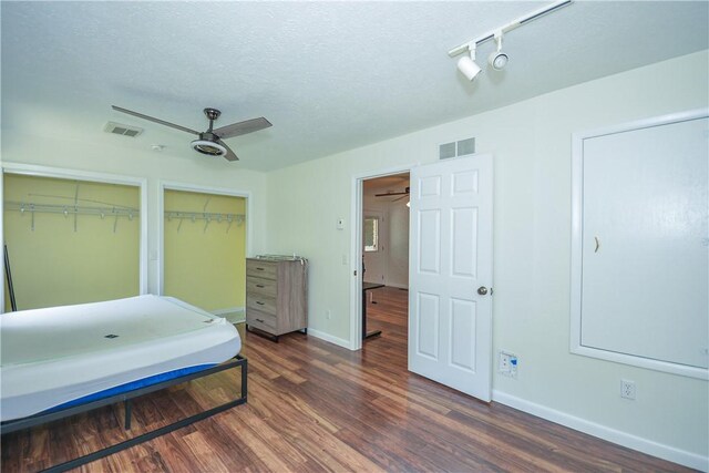 222 Green St, Auburn, AL 36830 - bedroom with two closets, wood finished floors, baseboards, a textured ceiling, and ceiling fan