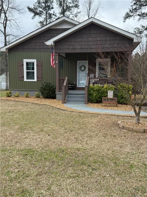 view of front of property with a porch and a front lawn