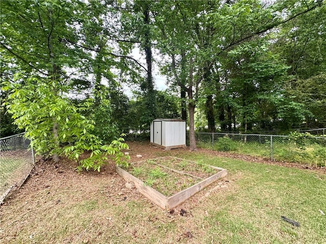 view of yard featuring a storage unit, a fenced backyard, an outbuilding, and a garden