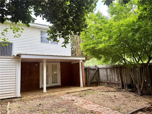 view of side of home featuring a fenced backyard and brick siding