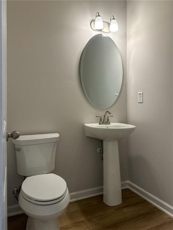 bathroom with toilet and wood-type flooring