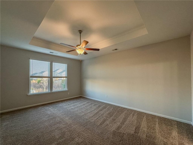 carpeted empty room featuring ceiling fan and a tray ceiling