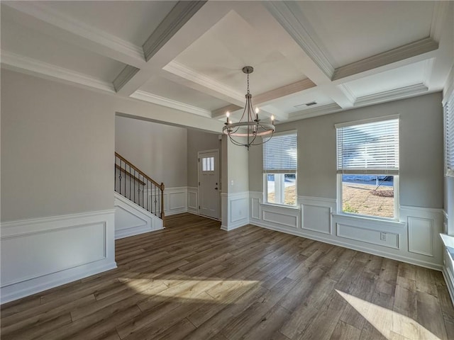 interior space with dark hardwood / wood-style floors, ornamental molding, a chandelier, beam ceiling, and coffered ceiling