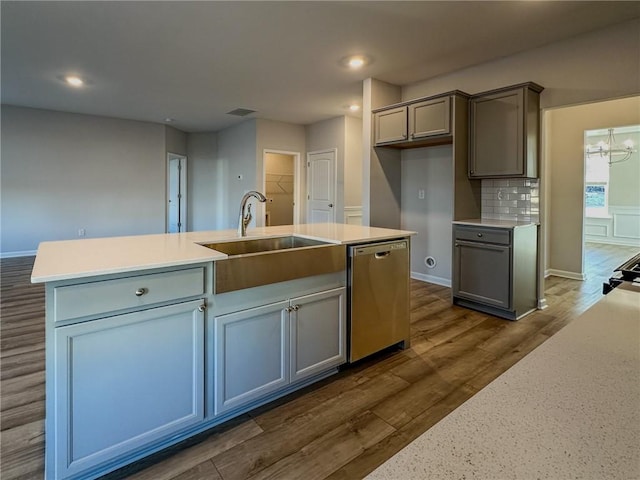 kitchen with dishwasher, decorative backsplash, sink, a kitchen island with sink, and dark hardwood / wood-style flooring