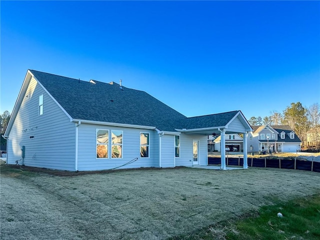 rear view of house featuring a patio area and a yard