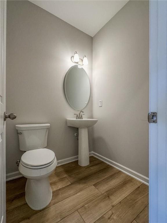 bathroom featuring toilet and wood-type flooring