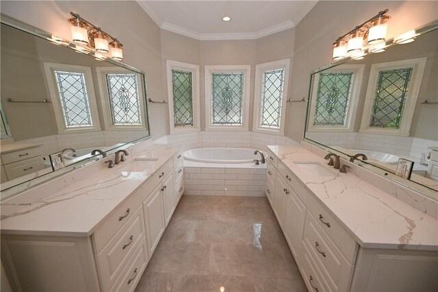 bathroom featuring tile patterned floors, vanity, crown molding, and tiled tub