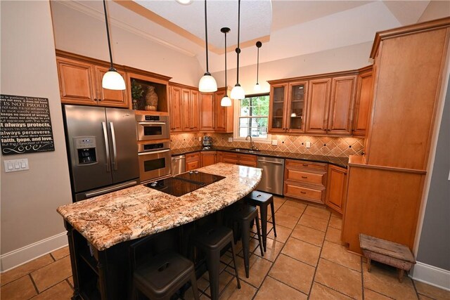 kitchen with decorative backsplash, dark stone counters, stainless steel appliances, sink, and a kitchen island