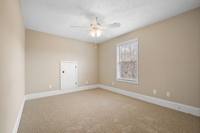 carpeted spare room featuring ceiling fan and a textured ceiling