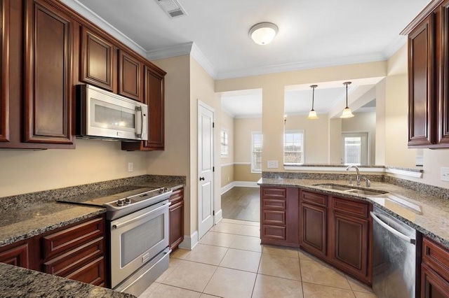 kitchen featuring stainless steel appliances, hanging light fixtures, sink, and dark stone countertops