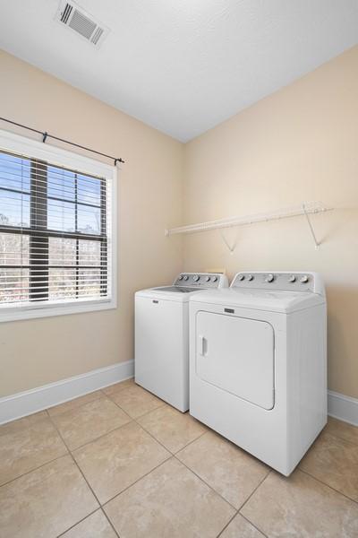 laundry room featuring separate washer and dryer and light tile patterned floors