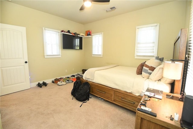 bedroom featuring visible vents, a ceiling fan, and light carpet