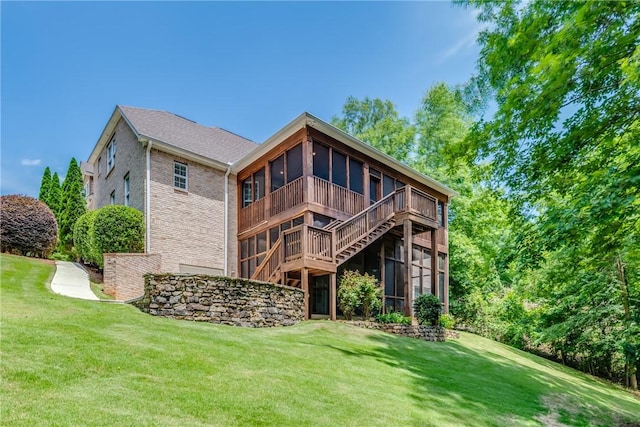 rear view of property featuring a lawn and a sunroom