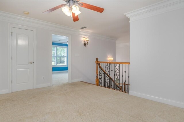 spare room featuring carpet flooring, ceiling fan, and ornamental molding