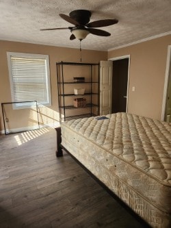 unfurnished bedroom featuring a textured ceiling, dark hardwood / wood-style floors, ceiling fan, and crown molding