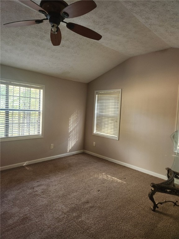 spare room featuring a textured ceiling, ceiling fan, lofted ceiling, and carpet floors