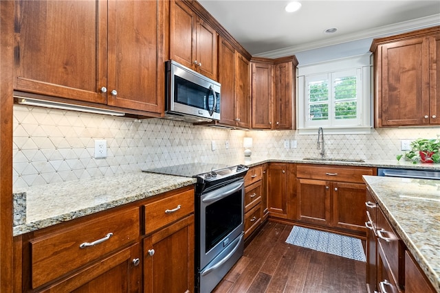 3515 Double Eagle Ln, Opelika, AL 36801 - kitchen featuring appliances with stainless steel finishes, a sink, dark wood-type flooring, ornamental molding, and light stone counters