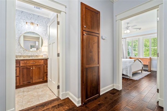 3515 Double Eagle Ln, Opelika, AL 36801 - hall with ornamental molding, dark wood-style flooring, baseboards, wallpapered walls, and a sink