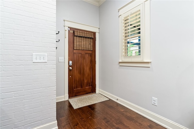 3515 Double Eagle Ln, Opelika, AL 36801 - entryway featuring dark wood-style floors, baseboards, brick wall, and ornamental molding